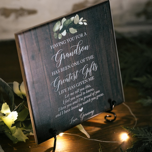 a wooden sign with flowers and lights on a table