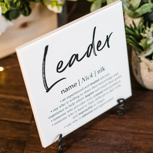 a sign that says leader on it on a table
