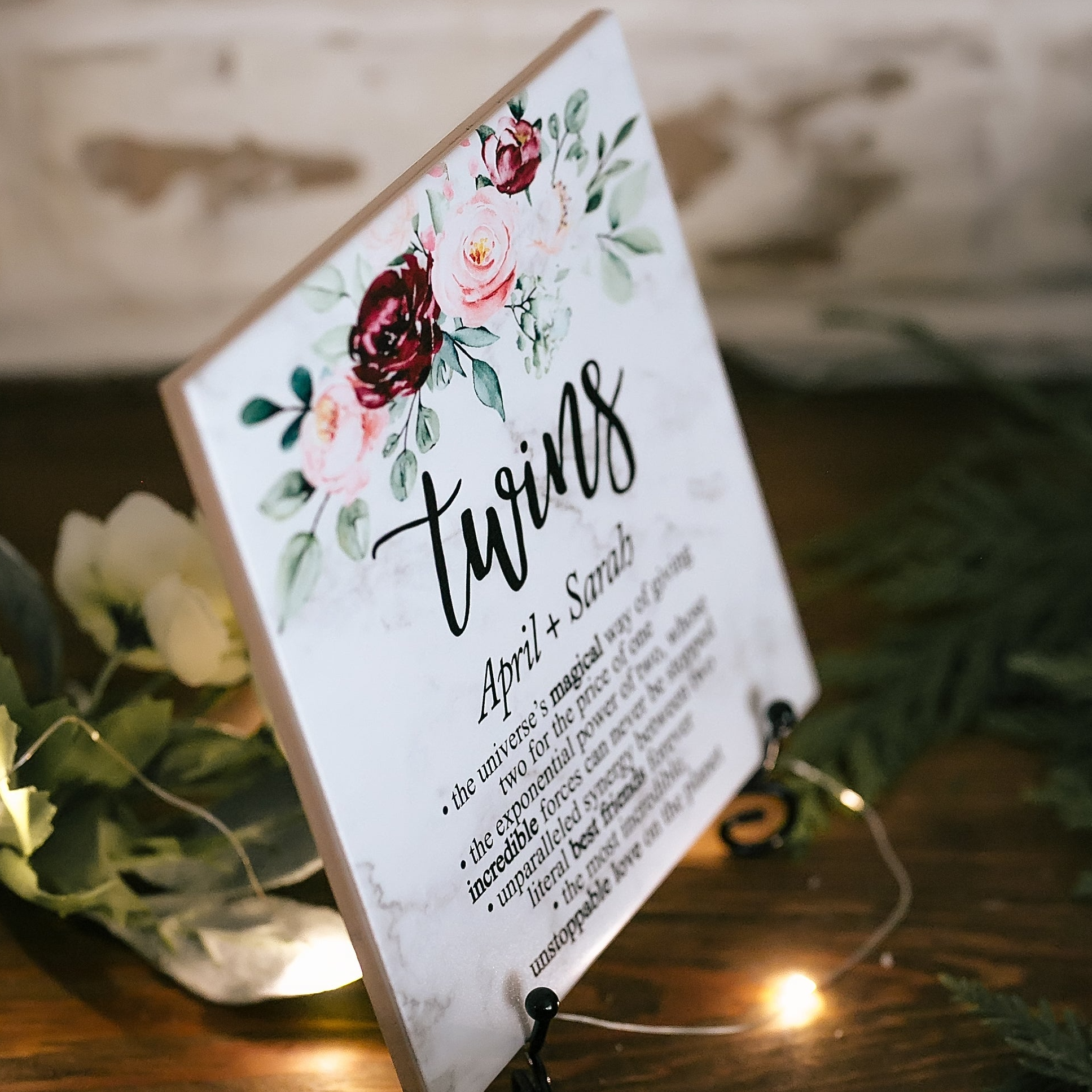 a wooden sign with flowers on it sitting on a table