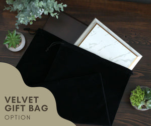 a black velvet gift bag sitting on top of a wooden table
